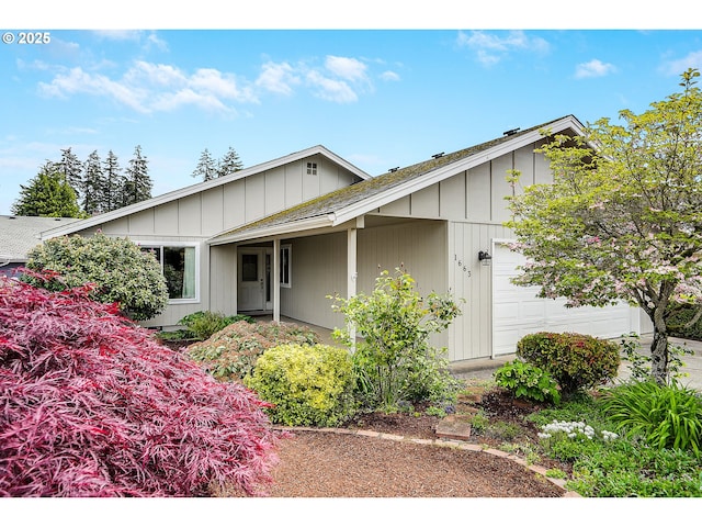 single story home with an attached garage and roof with shingles