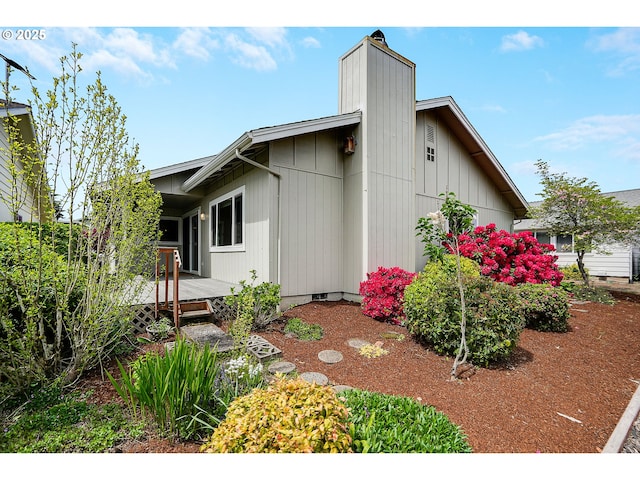 view of side of home featuring a deck and a chimney