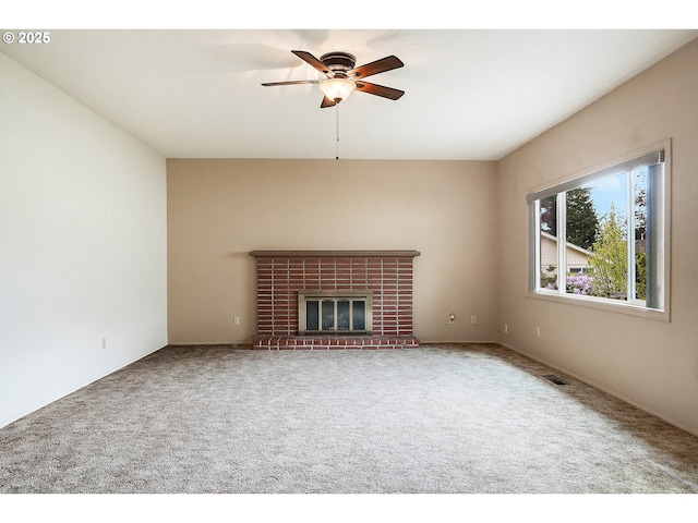 unfurnished living room with carpet floors, a ceiling fan, visible vents, and a fireplace