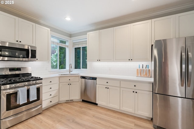 2233 NW Oxford St, Camas, WA 98607 - kitchen featuring appliances with stainless steel finishes, a sink, ornamental molding, light countertops, and white cabinetry