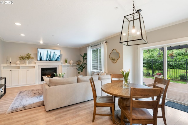 2233 NW Oxford St, Camas, WA 98607 - dining space featuring plenty of natural light, a glass covered fireplace, crown molding, light wood-type flooring, and recessed lighting