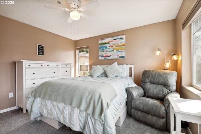 carpeted bedroom featuring baseboards, multiple windows, and a ceiling fan