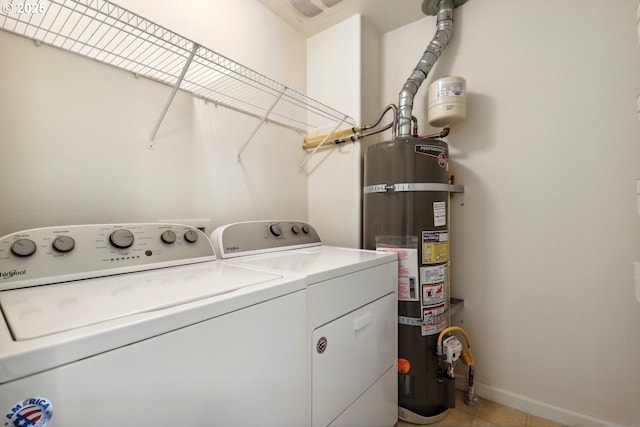 laundry room featuring laundry area, light tile patterned floors, baseboards, secured water heater, and washer and clothes dryer
