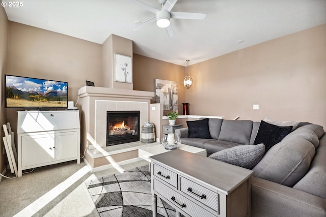 living area with a ceiling fan, baseboards, light colored carpet, and a tile fireplace