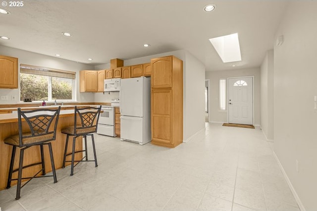 366 Pintail Ave SE, Salem, OR 97306 - kitchen featuring a skylight, a kitchen breakfast bar, white appliances, and recessed lighting