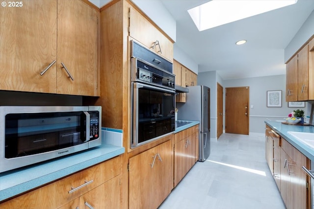 15 SW 95th Ave, Portland, OR 97225 - kitchen featuring stainless steel appliances, a skylight, light floors, light countertops, and a sink