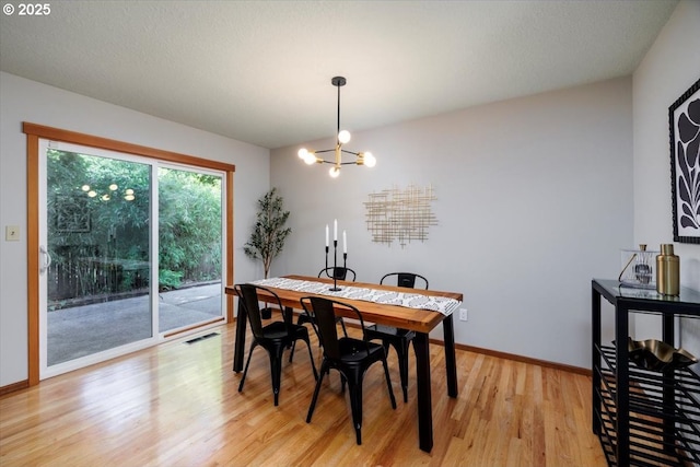 15 SW 95th Ave, Portland, OR 97225 - dining space featuring a chandelier, light wood-style floors, and baseboards