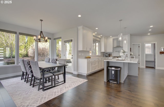 dining area featuring baseboards, a chandelier, dark wood finished floors, and recessed lighting