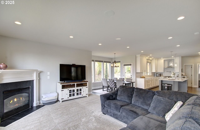 living room with a fireplace with flush hearth, baseboards, and recessed lighting