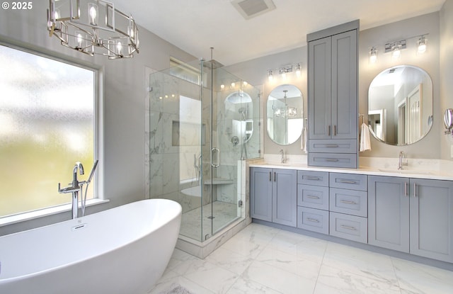 bathroom with marble finish floor, double vanity, a stall shower, and a sink