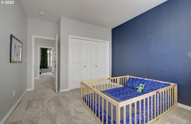 bedroom featuring carpet, baseboards, and a closet