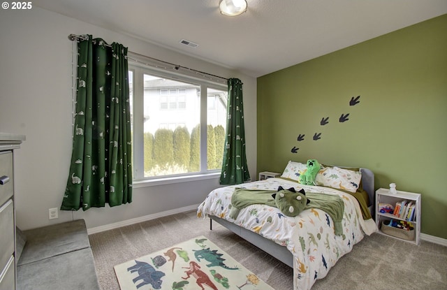 bedroom with baseboards, visible vents, and light colored carpet