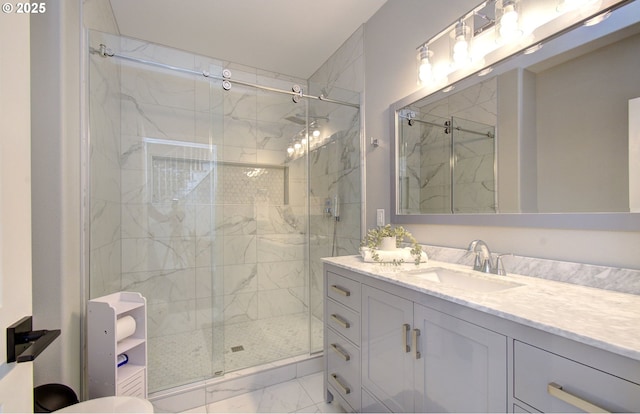 bathroom with marble finish floor, vanity, and a marble finish shower