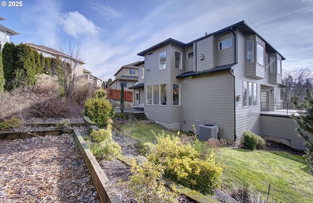 back of house with cooling unit and a yard