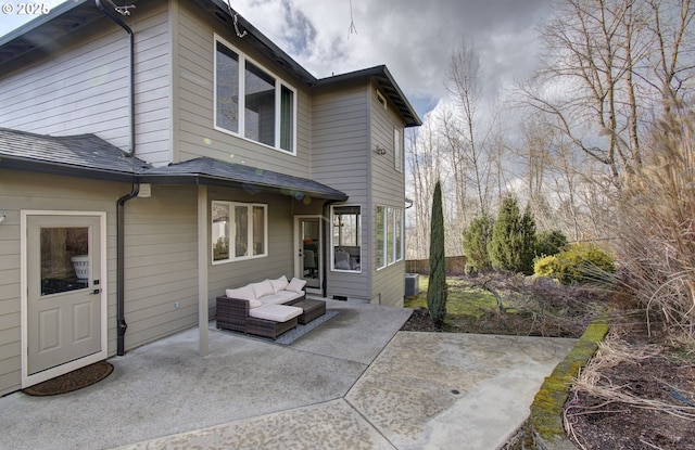 back of house with roof with shingles, outdoor lounge area, and a patio