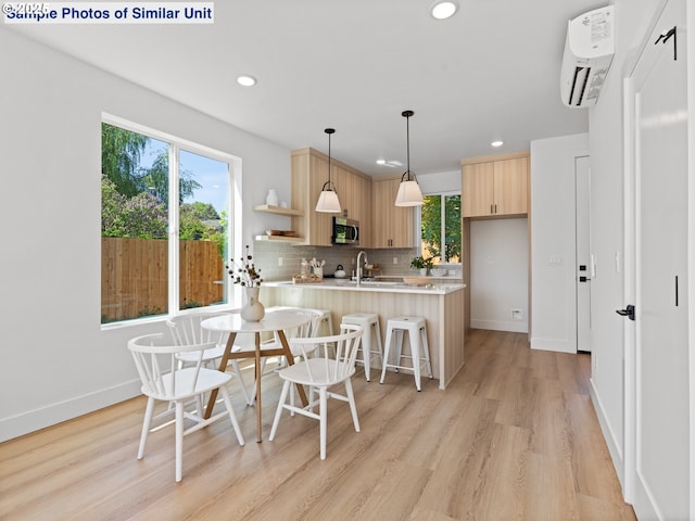 1218 SE Center St Unit 3, Portland, OR 97202 - kitchen featuring stainless steel microwave, light brown cabinetry, light countertops, a peninsula, and recessed lighting