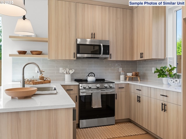 1218 SE Center St Unit 3, Portland, OR 97202 - kitchen featuring appliances with stainless steel finishes, light brown cabinetry, and a sink