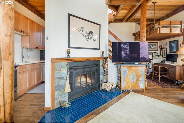 living room with beamed ceiling, dark hardwood / wood-style flooring, sink, and wooden ceiling