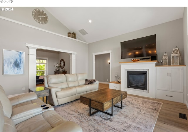 217 Deal Canyon Rd, La Grande, OR 97850 - living area with ornate columns, a glass covered fireplace, light wood-type flooring, high vaulted ceiling, and baseboards