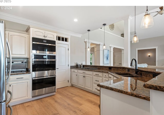 217 Deal Canyon Rd, La Grande, OR 97850 - kitchen featuring a sink, decorative columns, appliances with stainless steel finishes, light wood-type flooring, and decorative light fixtures