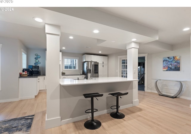 217 Deal Canyon Rd, La Grande, OR 97850 - kitchen featuring appliances with stainless steel finishes, ornate columns, white cabinetry, light wood finished floors, and baseboards