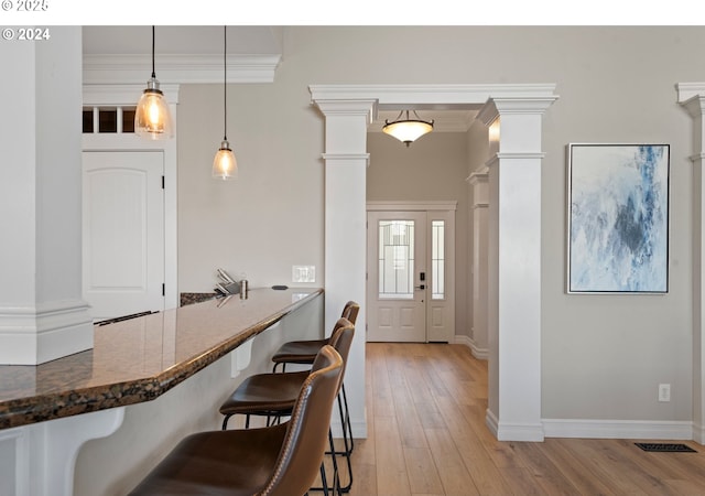 217 Deal Canyon Rd, La Grande, OR 97850 - kitchen with ornate columns, a kitchen breakfast bar, light wood finished floors, and crown molding