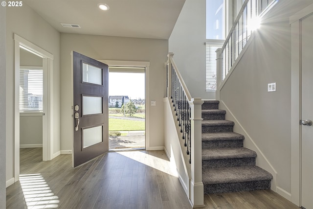 foyer with stairway, wood finished floors, visible vents, baseboards, and recessed lighting