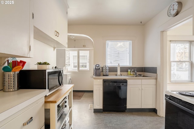 kitchen with dishwasher, white cabinets, plenty of natural light, and sink