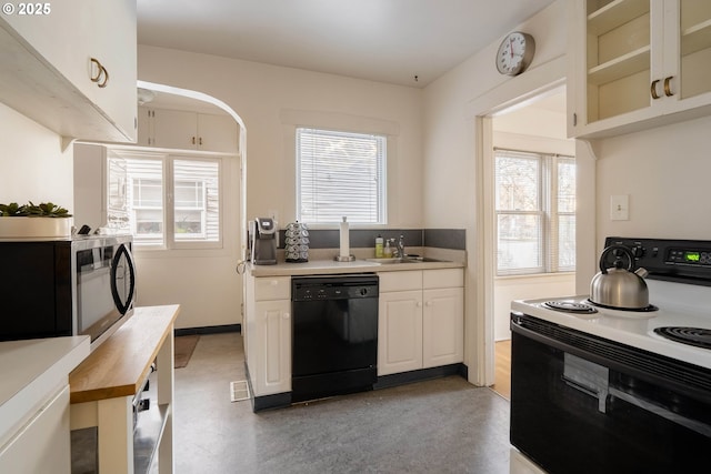 kitchen with plenty of natural light, white cabinets, black dishwasher, butcher block countertops, and white electric range oven