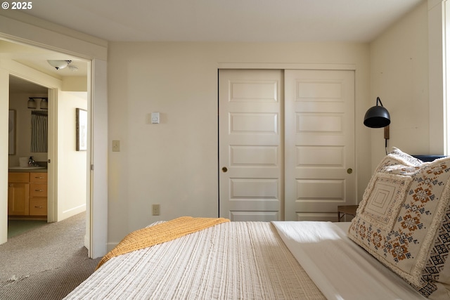 bedroom featuring carpet flooring, connected bathroom, a closet, and sink