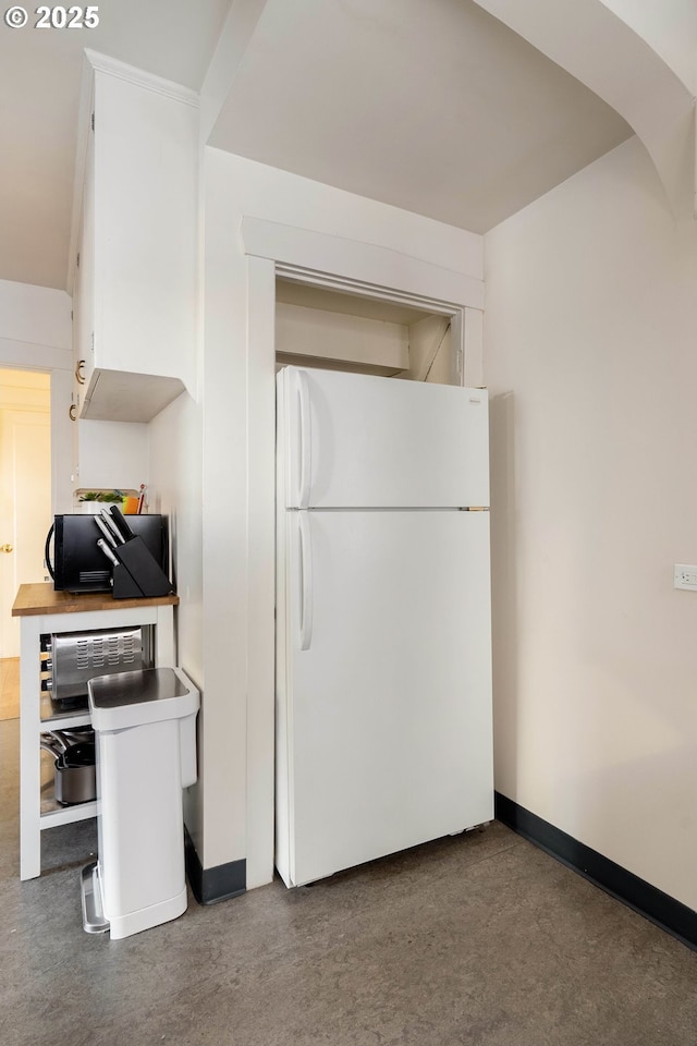 kitchen featuring white cabinetry and white fridge