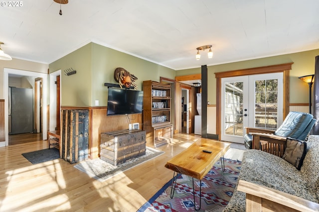 living room featuring light hardwood / wood-style flooring, ornamental molding, and french doors