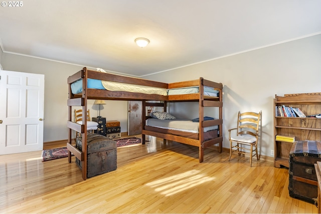 bedroom with wood-type flooring and crown molding