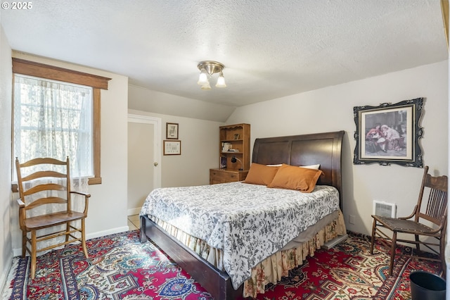 bedroom with a textured ceiling and lofted ceiling