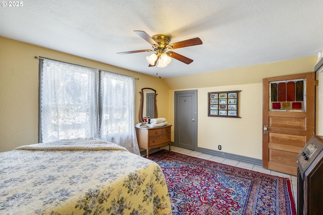 tiled bedroom featuring ceiling fan and a textured ceiling