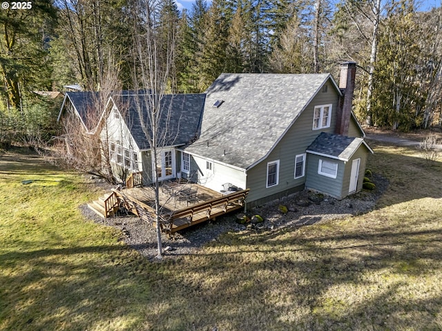 rear view of house with a deck and a lawn