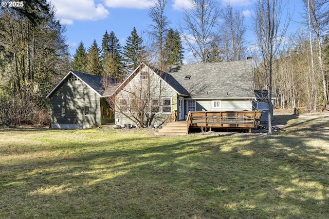 rear view of house with a deck and a yard