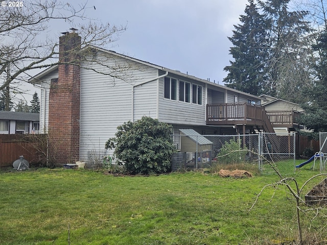 back of property featuring a wooden deck and a yard