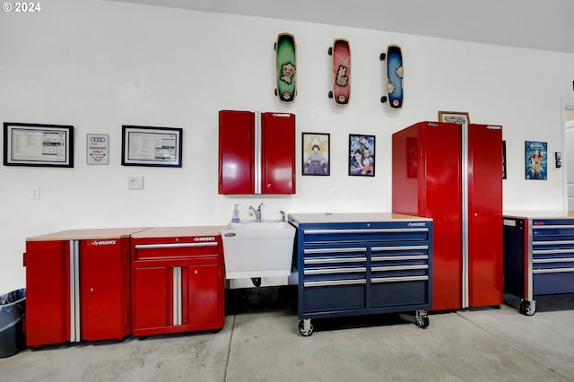 miscellaneous room with concrete floors and a sink