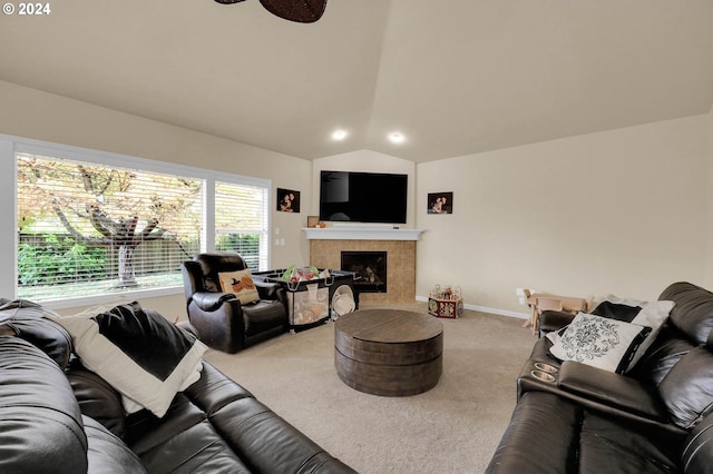 carpeted living room with lofted ceiling, baseboards, and a tiled fireplace