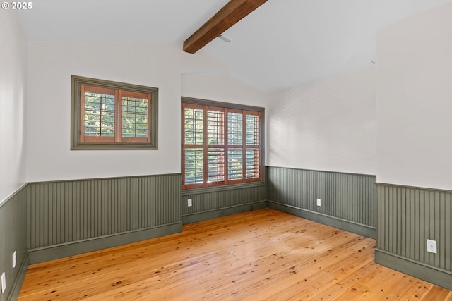 unfurnished room featuring vaulted ceiling with beams and wood-type flooring