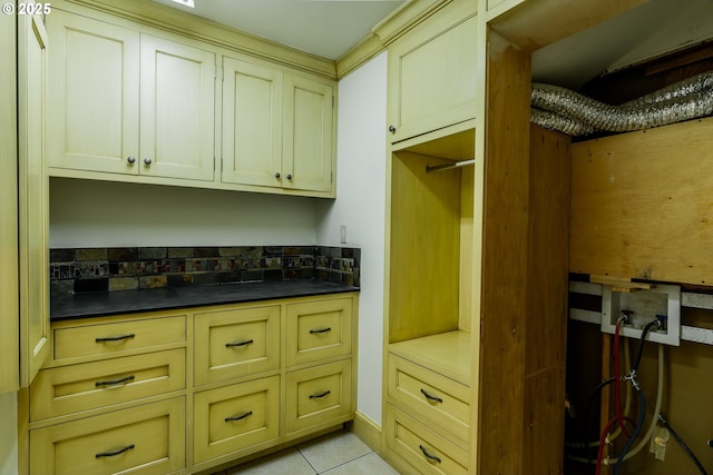 interior space with light tile patterned floors and cream cabinets