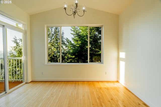 spare room featuring vaulted ceiling, a chandelier, and light hardwood / wood-style floors