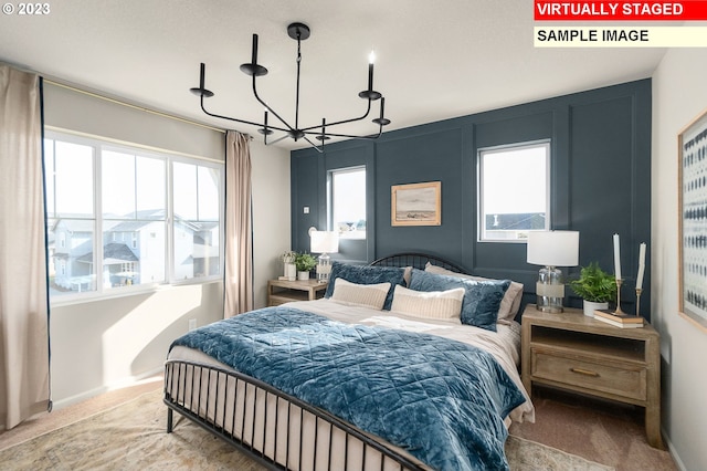 carpeted bedroom with baseboards and an inviting chandelier