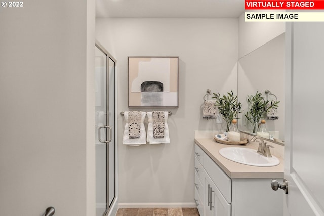 full bath featuring vanity, a shower stall, and baseboards