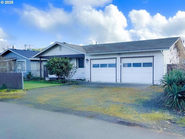 ranch-style home featuring driveway, a shingled roof, a garage, and fence