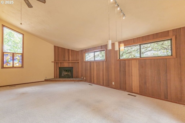 2116 Sally Way, Eugene, OR 97401 - unfurnished living room featuring wooden walls, a fireplace, carpet, track lighting, and lofted ceiling