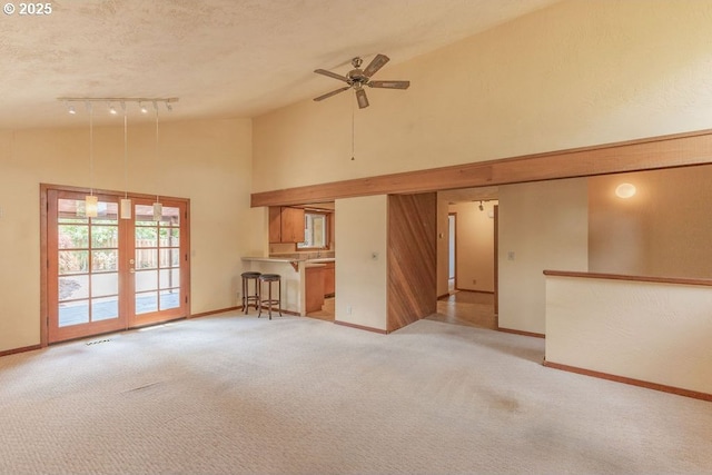 2116 Sally Way, Eugene, OR 97401 - unfurnished living room featuring high vaulted ceiling, light colored carpet, a ceiling fan, french doors, and rail lighting