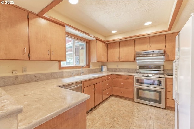 2116 Sally Way, Eugene, OR 97401 - kitchen with range with two ovens, freestanding refrigerator, under cabinet range hood, light countertops, and recessed lighting