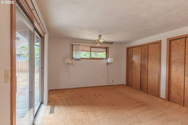 2116 Sally Way, Eugene, OR 97401 - unfurnished bedroom with access to outside, two closets, carpet, and ceiling fan